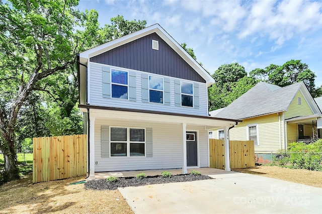 view of front of property with a porch and fence