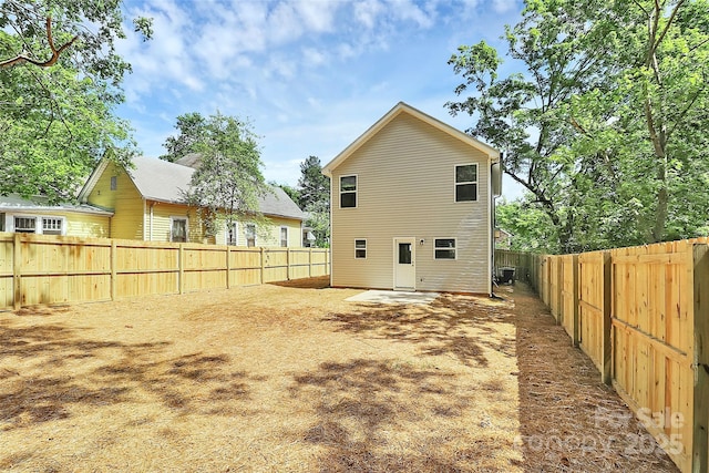 back of house with a fenced backyard