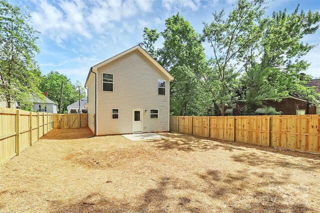 rear view of property featuring a fenced backyard