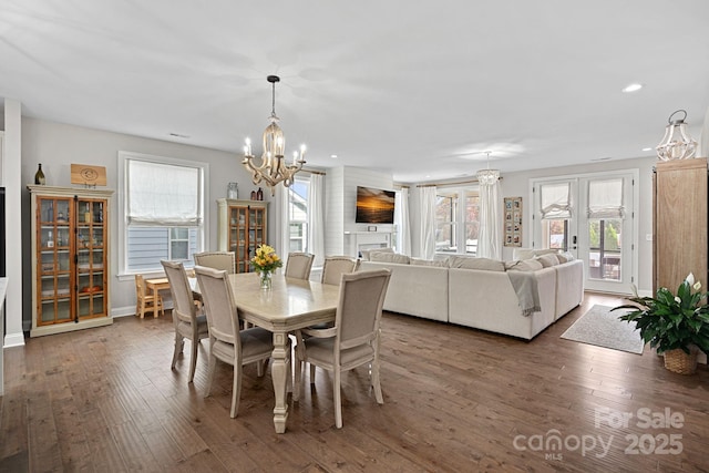 dining space with dark hardwood / wood-style floors, a chandelier, and french doors