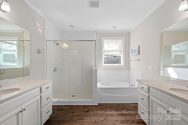 bathroom featuring hardwood / wood-style flooring, plenty of natural light, crown molding, and independent shower and bath