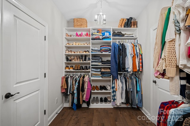 spacious closet with dark wood-type flooring and a notable chandelier