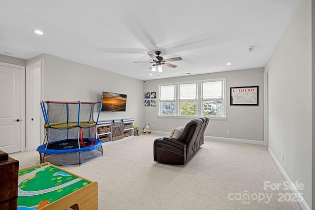 game room with ceiling fan and light carpet