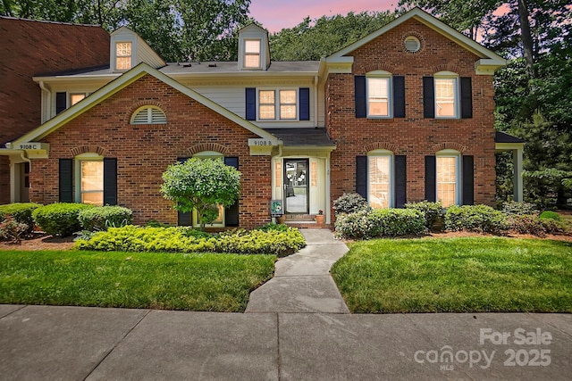 view of front of house with brick siding and a front yard