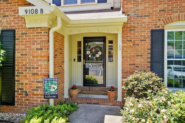 doorway to property featuring brick siding