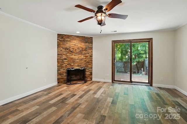 unfurnished living room with baseboards, ornamental molding, wood finished floors, and a fireplace