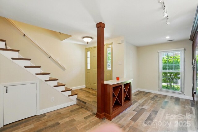 entrance foyer featuring stairway, baseboards, light wood-style flooring, and visible vents