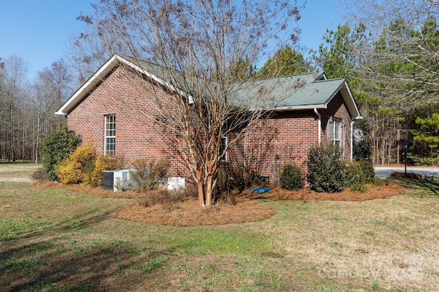 view of side of home featuring cooling unit and a lawn