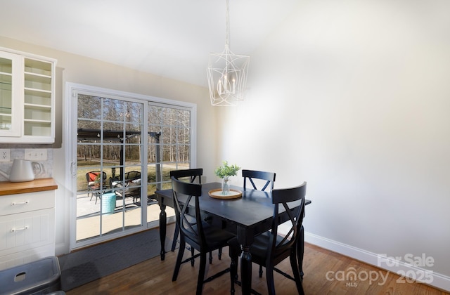 dining area with dark hardwood / wood-style flooring and a notable chandelier