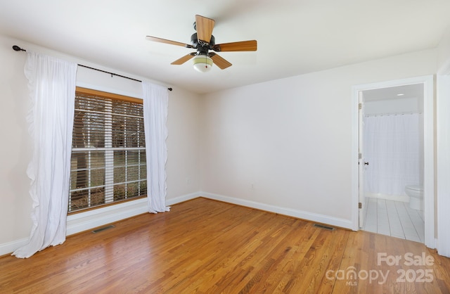 empty room with hardwood / wood-style floors and ceiling fan