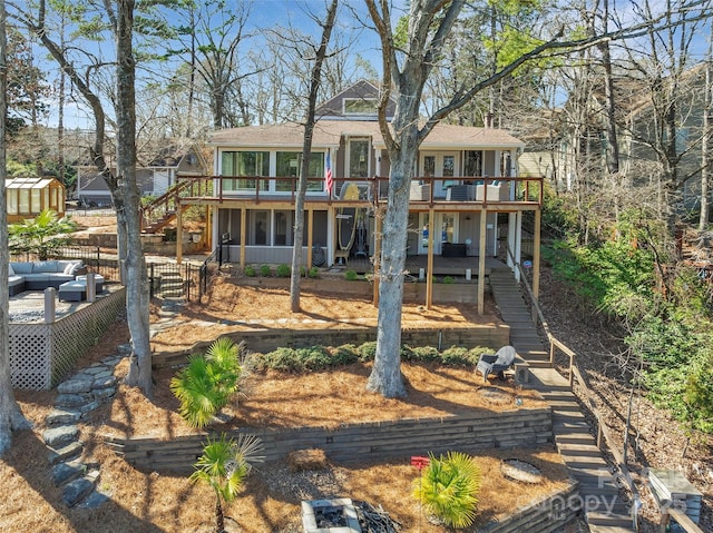 back of house featuring an outdoor living space, a wooden deck, roof with shingles, and stairs