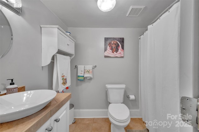 bathroom with tile patterned flooring, visible vents, baseboards, toilet, and vanity