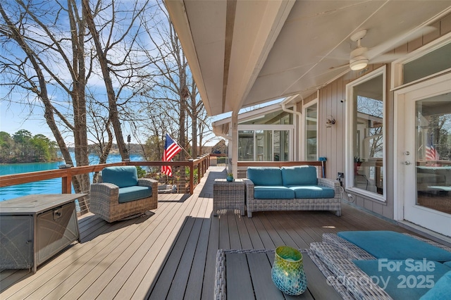 wooden deck with a water view and an outdoor hangout area