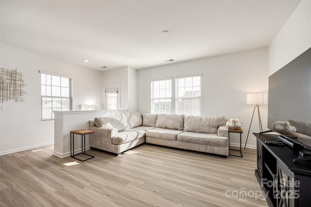 living room featuring a wealth of natural light and light wood-type flooring