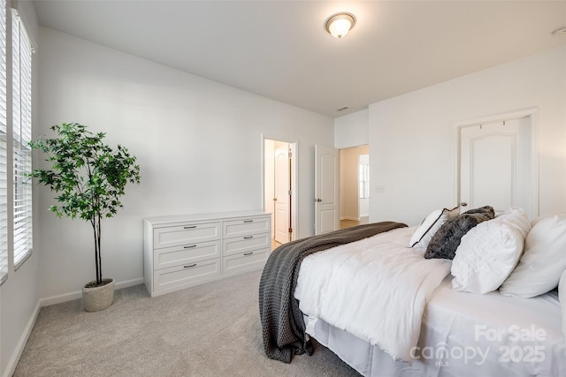 bedroom with light carpet and ensuite bath