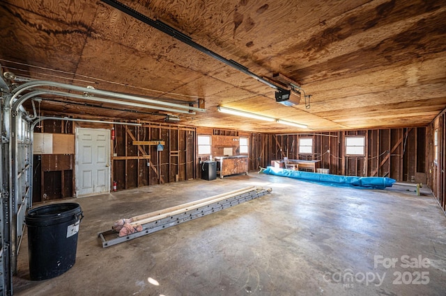 garage featuring a garage door opener and wooden ceiling