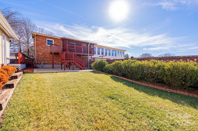 back of property featuring a patio, a yard, and a sunroom