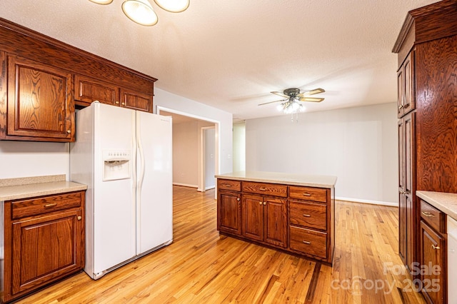 kitchen featuring ceiling fan, light wood-type flooring, a textured ceiling, and white fridge with ice dispenser