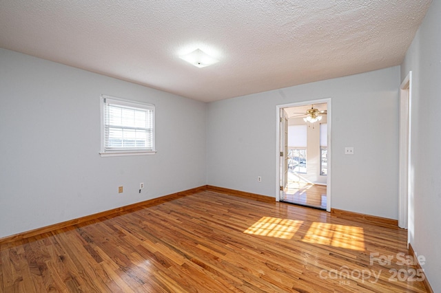 spare room featuring wood-type flooring and a textured ceiling