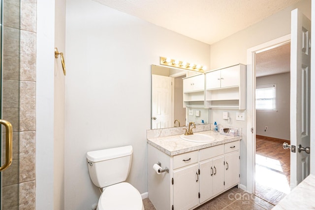 bathroom with vanity, an enclosed shower, a textured ceiling, and toilet