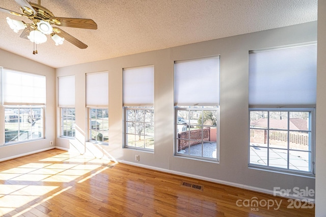 interior space featuring ceiling fan, light hardwood / wood-style floors, and a textured ceiling