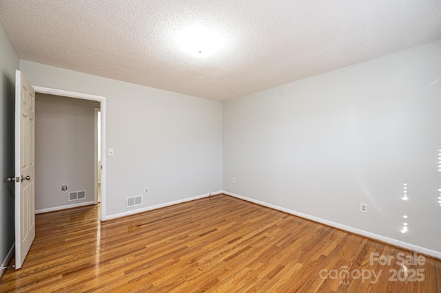 spare room with wood-type flooring and a textured ceiling