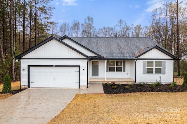 single story home featuring an attached garage, driveway, a porch, and a shingled roof