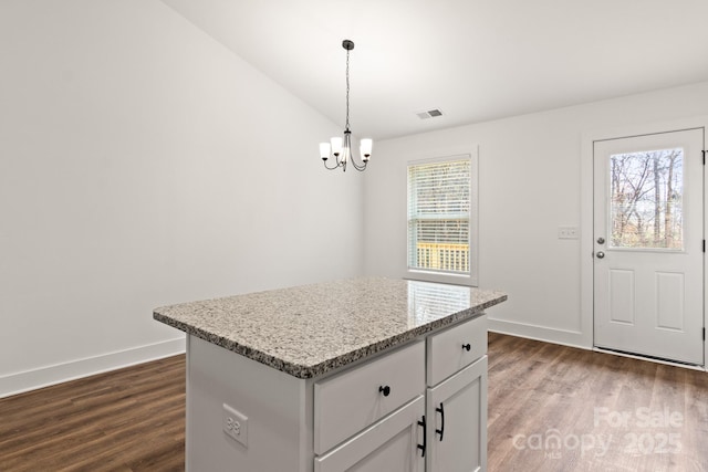 kitchen with pendant lighting, white cabinetry, a center island, and dark wood-type flooring