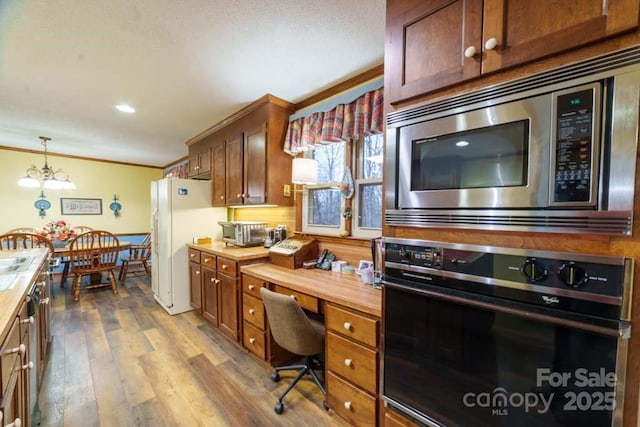 kitchen with crown molding, light hardwood / wood-style flooring, stainless steel microwave, white fridge with ice dispenser, and oven