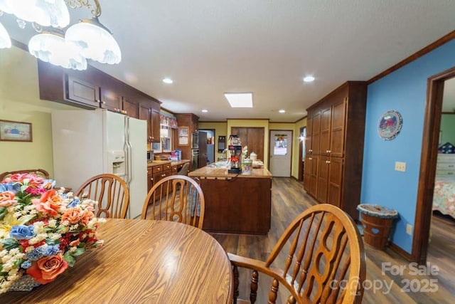 dining area with ornamental molding, dark hardwood / wood-style floors, and sink