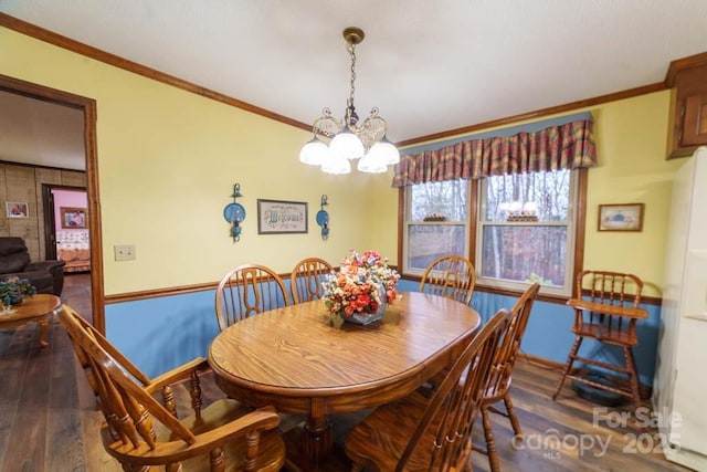 dining area featuring hardwood / wood-style floors, ornamental molding, and a chandelier