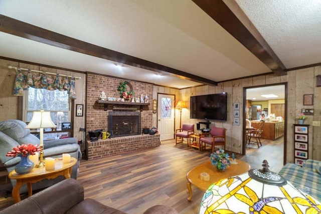 living room featuring hardwood / wood-style floors, a fireplace, wood walls, beam ceiling, and a textured ceiling