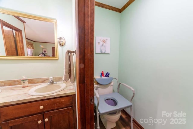 bathroom featuring vanity, ornamental molding, and toilet