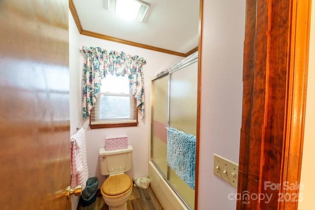 bathroom featuring hardwood / wood-style flooring, enclosed tub / shower combo, ornamental molding, and toilet