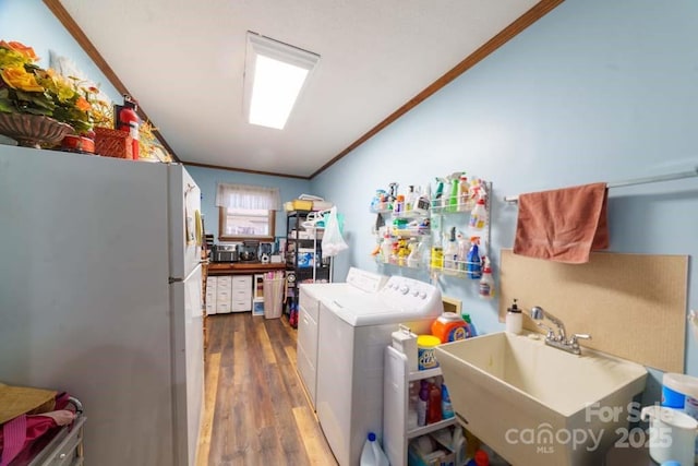 laundry room featuring crown molding, separate washer and dryer, sink, and dark wood-type flooring