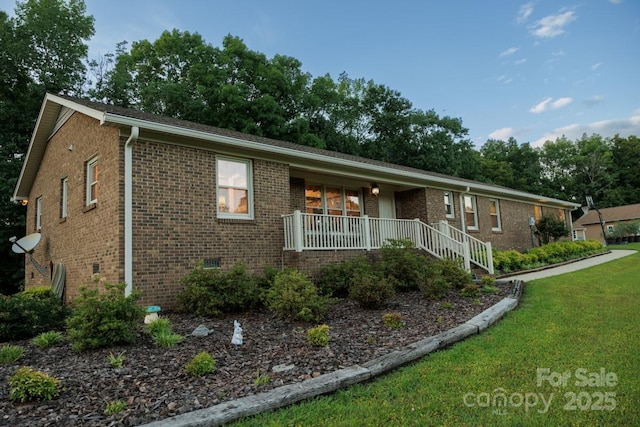 4816 Zion Church Rd, Concord, NC 28025 - ranch-style home with a porch, brick siding, a front lawn, and view of scattered trees