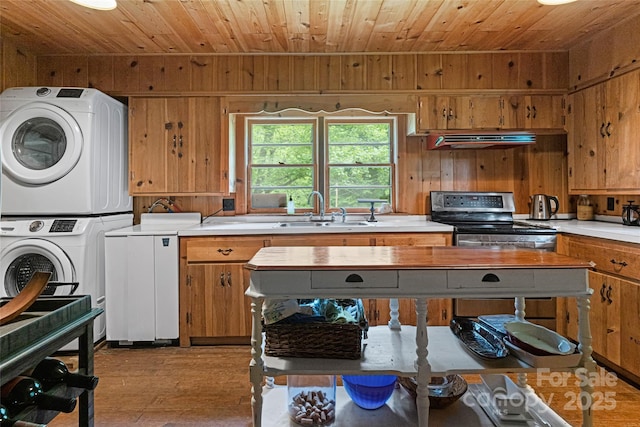 kitchen with stacked washer and dryer, sink, stainless steel range with electric cooktop, wooden ceiling, and exhaust hood