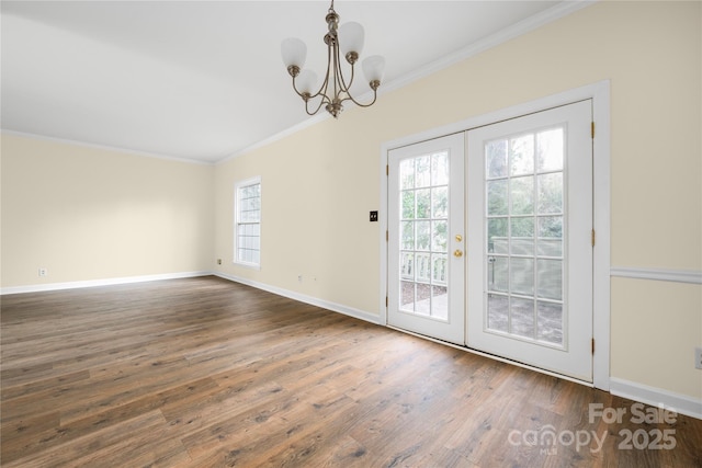 entryway with crown molding, an inviting chandelier, dark wood-type flooring, and french doors