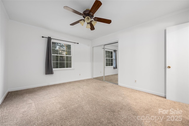 unfurnished bedroom with multiple windows, a closet, ceiling fan, and carpet