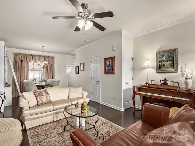 living room featuring dark wood-type flooring, ornamental molding, and ceiling fan with notable chandelier