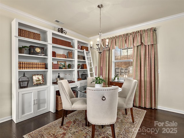 dining room with ornamental molding, dark wood-type flooring, built in desk, and a chandelier