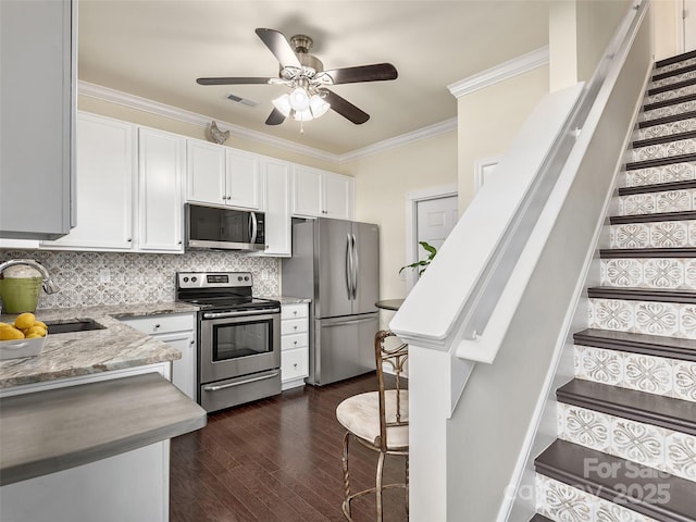 kitchen featuring sink, crown molding, stainless steel appliances, light stone counters, and white cabinets