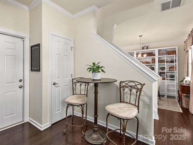 staircase featuring an inviting chandelier, hardwood / wood-style floors, and crown molding