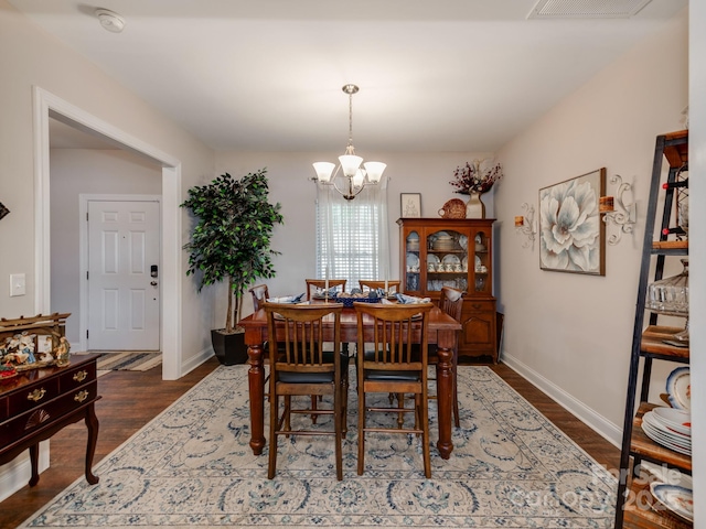 dining room featuring dark hardwood / wood-style floors and a chandelier