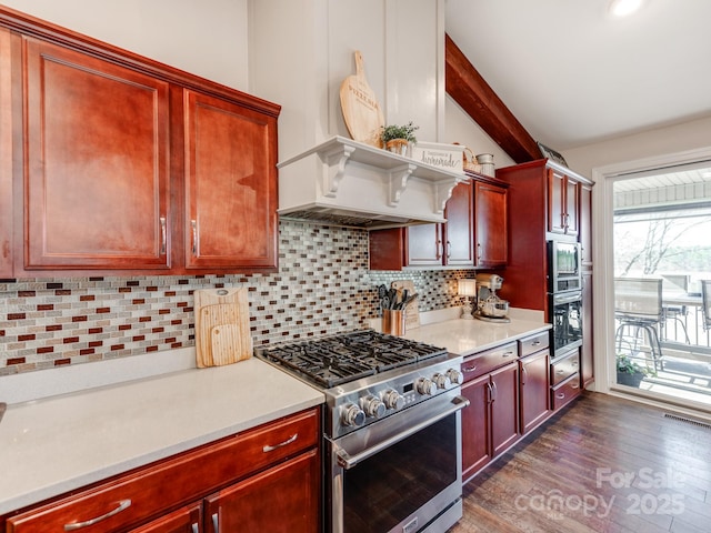 kitchen featuring appliances with stainless steel finishes, dark wood-type flooring, vaulted ceiling, and tasteful backsplash