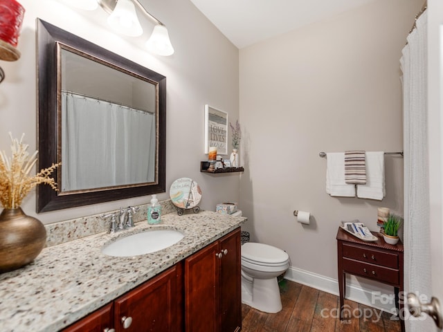 bathroom featuring vanity, toilet, and hardwood / wood-style floors