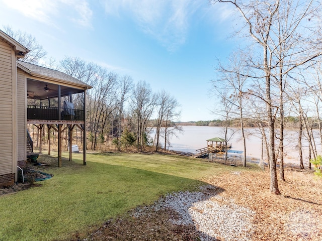 view of yard with ceiling fan and a water view