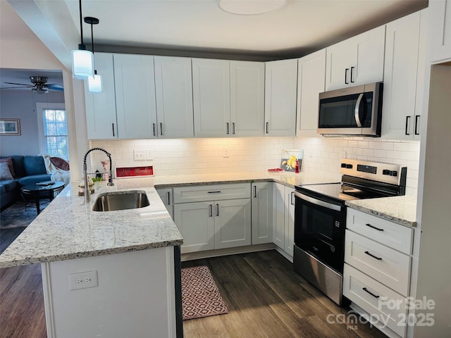 kitchen featuring sink, appliances with stainless steel finishes, white cabinetry, hanging light fixtures, and kitchen peninsula