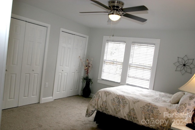 carpeted bedroom with two closets and ceiling fan