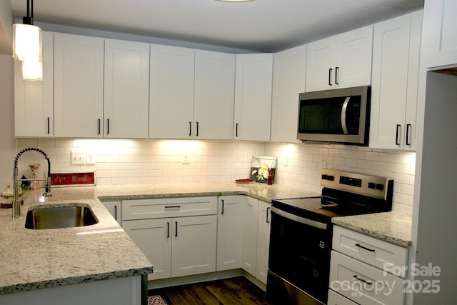 kitchen featuring sink, white cabinetry, light stone counters, hanging light fixtures, and electric range